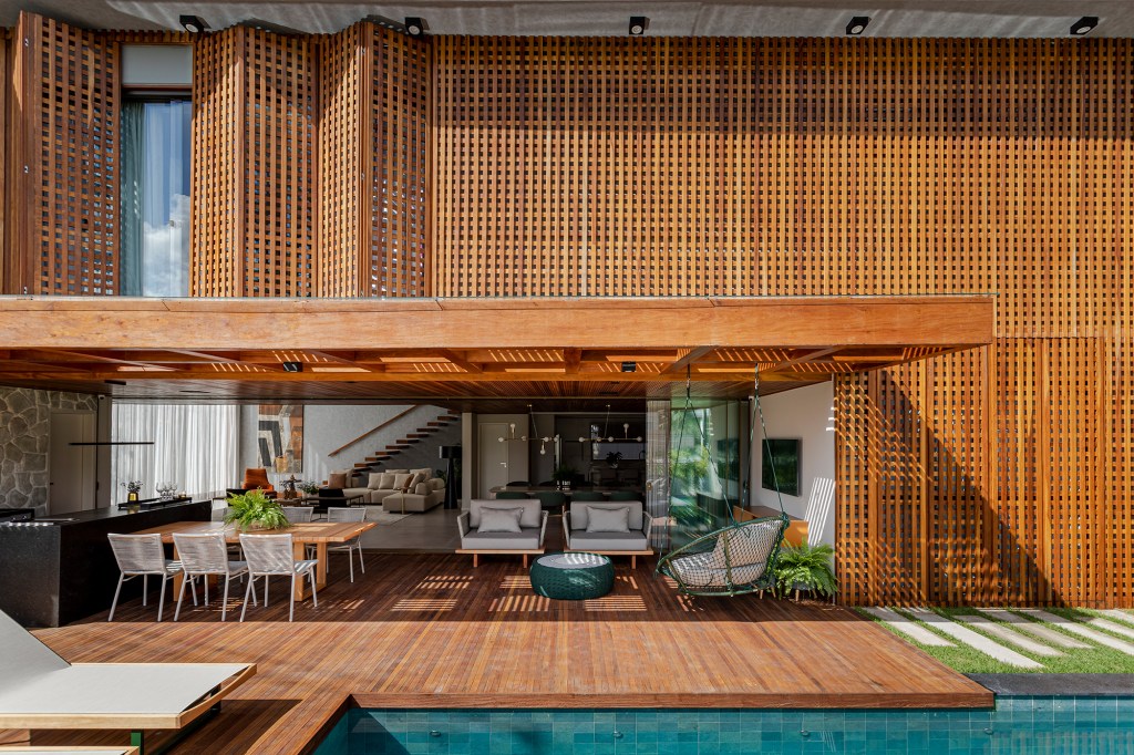 Fachada de muxarabis filtra o sol nesta casa de 430 m² na Bahia. Projeto de Sidney Quintela. Na foto, varanda, fachada e piscina.
