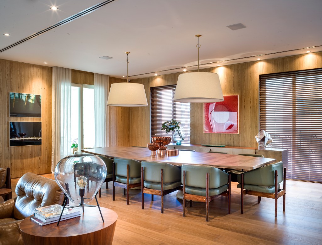 paola-ribeiro-apartamento-810-m2-repleto-arte-credito-romulo-fialdini (4) Paola Ribeiro assina apartamento de 810 m² repleto de arte. Na foto, sala de jantar com parede de madeira e quadros.
