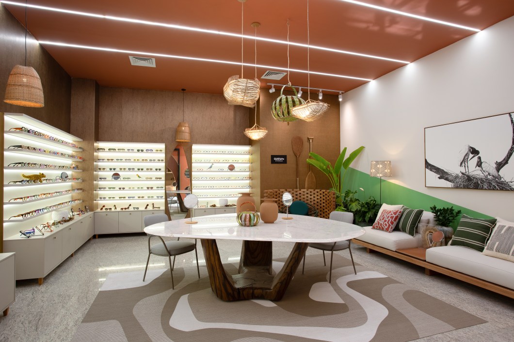 Ana Lívero - Ótica Gustavo Eyewear. Referência em biofilia e brasilidade, Ana Lívero faz uma leitura delicada e sofisticada da Ótica Gustavo Eyewear para apresentar óculos exclusivos. A assinatura do ambiente trouxe design biofílico, materiais naturais, arte popular de Mato Grosso e design brasileiro, como as lanternas pintadas pelo artista Lupércio, os quadros de João Sebastião e Júlio Cesar, o texto escrito à mão pela artista Ruth Albernaz e o grafismo indígena de Waxamani Mehinako dando boas-vindas. Ana Lívero - Ótica Gustavo Eyewear. Referência em biofilia e brasilidade, Ana Lívero faz uma leitura delicada e sofisticada da Ótica Gustavo Eyewear para apresentar óculos exclusivos. A assinatura do ambiente trouxe design biofílico, materiais naturais, arte popular de Mato Grosso e design brasileiro, como as lanternas pintadas pelo artista Lupércio, os quadros de João Sebastião e Júlio Cesar, o texto escrito à mão pela artista Ruth Albernaz e o grafismo indígena de Waxamani Mehinako dando boas-vindas.