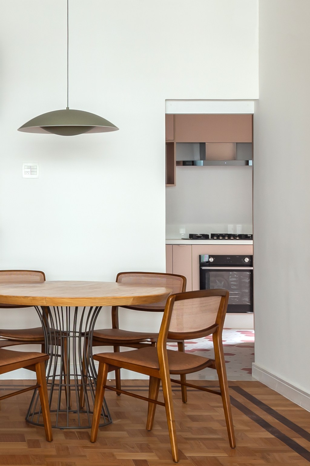 Apê de 145 m² ganha charme com tijolinhos, ladrilho hidráulico e patchwork. Na foto, sala de jantar com mesa redonda. Cozinha rosa.