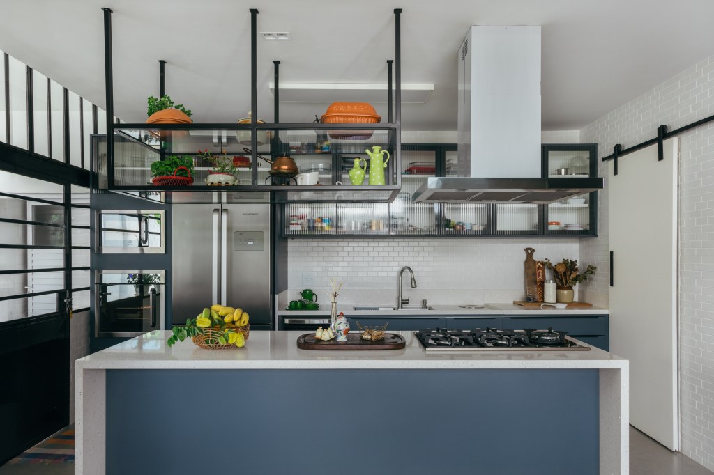 Casa no Parque Guinle une peças de família e décor contemporâneo. Projeto de Ana Cano. Na foto, cozinha com ilha azul, armários de serralheria e subway tiles.