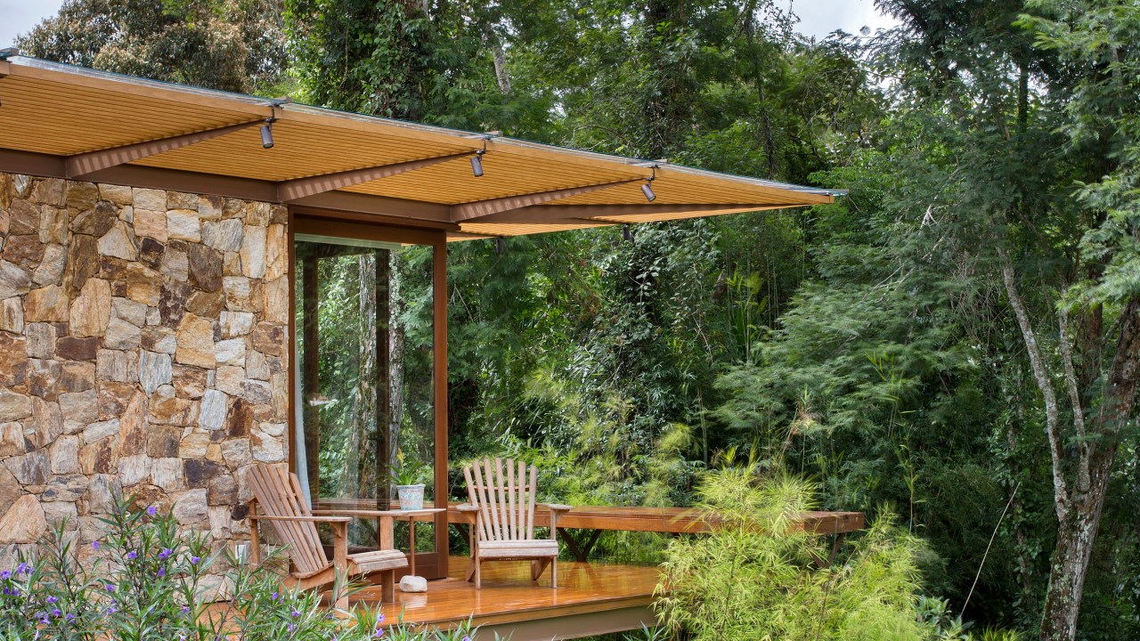 Suíte de casa de campo fica em bangalô suspenso no meio da natureza. Projeto de Escala Arquitetura. Na foto, varanda suspensa do quarto.