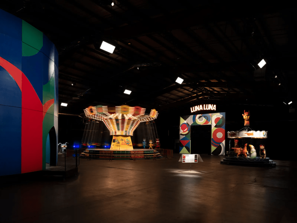 A árvore Encantada de David Hockney, o balanço da cadeira pintada de Kenny Scharf, o arco de entrada de Sonia Delaunay e o carrossel de Arik Brauer /