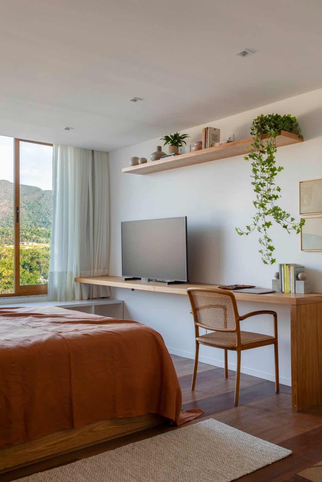 casa-de-campo-800-m2-petropolis-decor-cara-montanha-joao-panaggio-credito-denilson-machado (18) Casa de campo de 800 m² em Petrópolis ganha décor com cara de montanha. Projeto de João Panaggio. Na foto, quarto de casal com tv e vista para a natureza.
