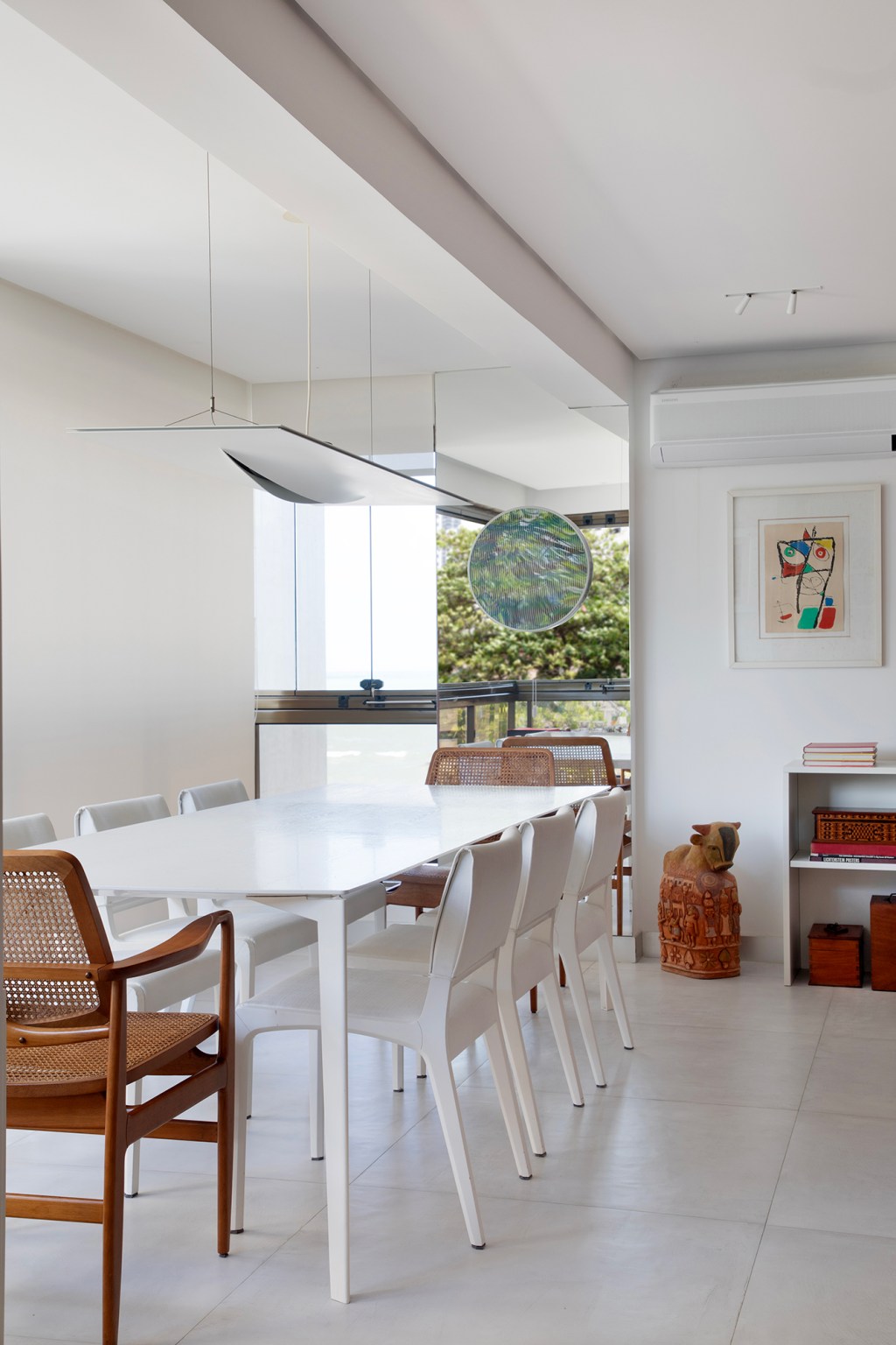 Conheça o apê da arquiteta Ana Moura, do elenco da CASACOR Pernambuco. Na foto, sala de jantar com móveis brancos e de palha.