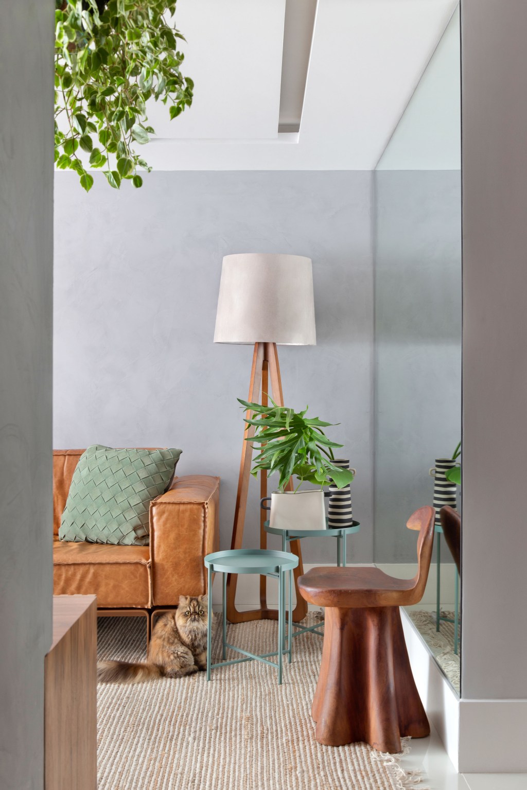 Cobertura duplex em Camboinhas NITERÓI RJ assinada pela TRAVESSA ARQUITETURA _ foto 2 Sem quebra-quebra, apê de 130 m² no Rio ganha décor cozy e minimalista. Projeto Travessa Arquitetura. Na foto, sala com sofá de couro, quadro e tapete.