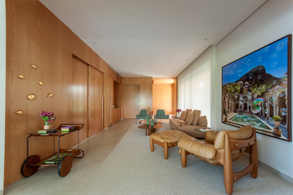 construida-do-zero-casa-ambientes-integrados-design-nacional-paiva-passarini-credito-xavier-neto (4) Construída do zero, casa une ambientes integrados e design nacional. Projeto de Paiva e Passarini Arquitetura. Na foto, sala de estar com painel de madeira e quadros.