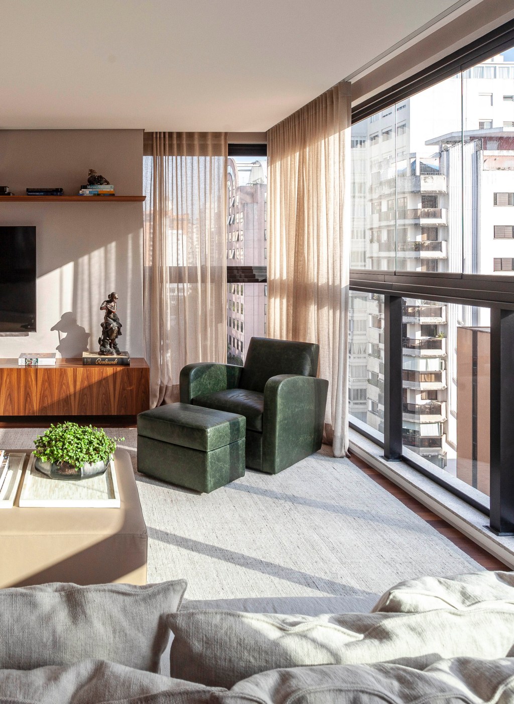 david-bastos-apartamento-classico-174-m2-sao-paulo-credito-tuca-reines (13) David Bastos assina apartamento clássico de 174 m² em São Paulo. Na foto, sala de TV com sofá em L, cortinas e poltrona verde.
