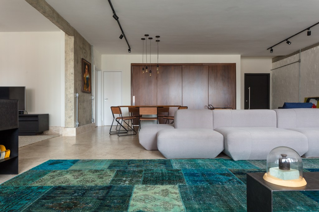 José Navarro assina apartamento de 210 m² no Conjunto Nacional, em SP. Na foto, sala de estar com tapete e sofá-ilha.