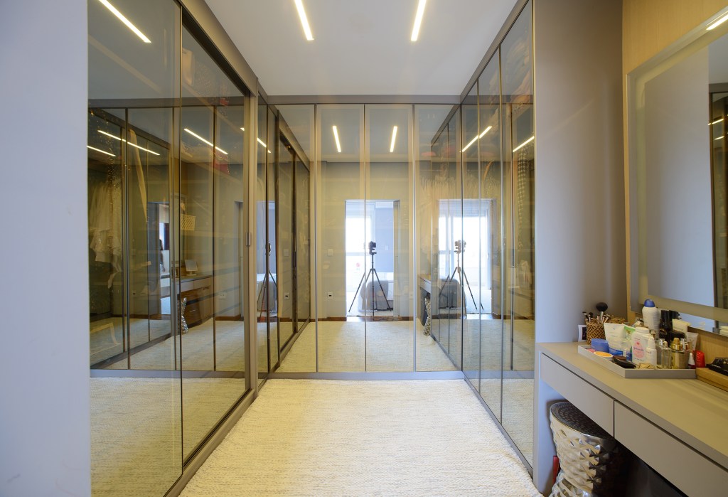 moveis-contemporaneos-paredes-amadeiradas-ape-138-m2-leticia-nanetti-credito-edson-ferreira (17) Móveis contemporâneos e paredes amadeiradas marcam este apê de 138 m². Projeto de Leticia Nanetti. Na foto, closet com paredes traslúcidas.