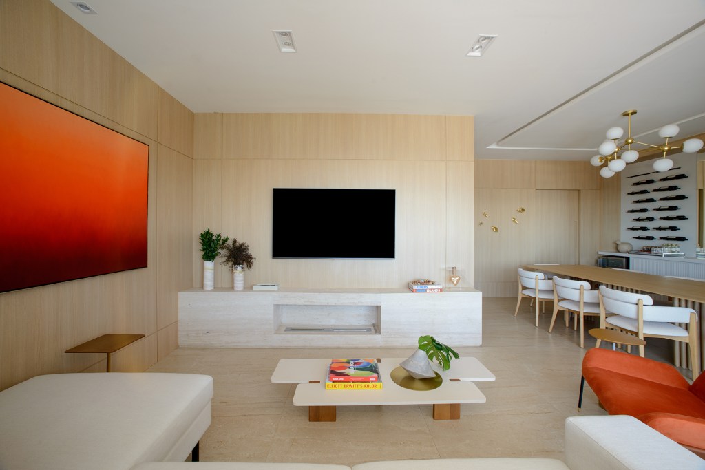 moveis-contemporaneos-paredes-amadeiradas-ape-138-m2-leticia-nanetti-credito-edson-ferreira (9) Móveis contemporâneos e paredes amadeiradas marcam este apê de 138 m². Projeto de Leticia Nanetti. Na foto, sala de estar com sofá branco e quadro laranja. Sala de jantar e adega.