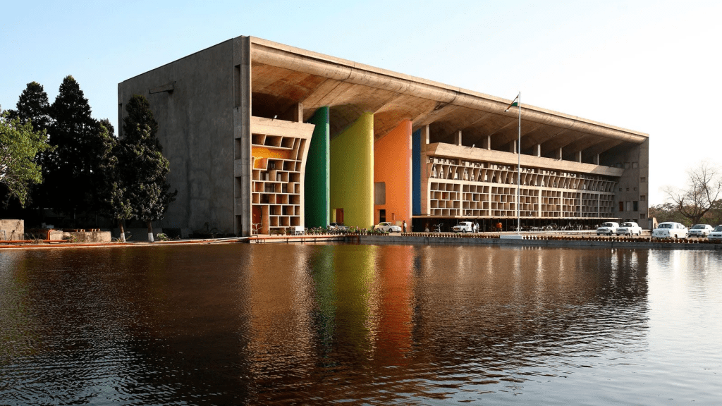 Le Corbusier- Chandigarh, Índia O Tribunal Superior de Chandigarh apresenta um pórtico com postes de cores vivas que contrastam com o concreto bruto do edifício