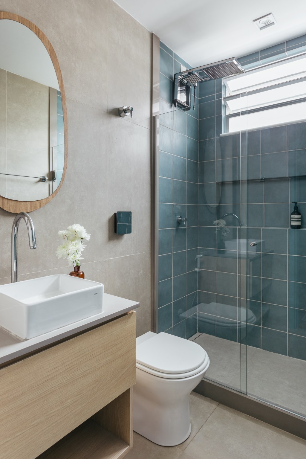Apê de 25 m² ganha décor praiana com parede de cerâmica azul. Projeto de Rodolfo Consoli. Na foto, banheiro com parede azul e espelho orgânico.