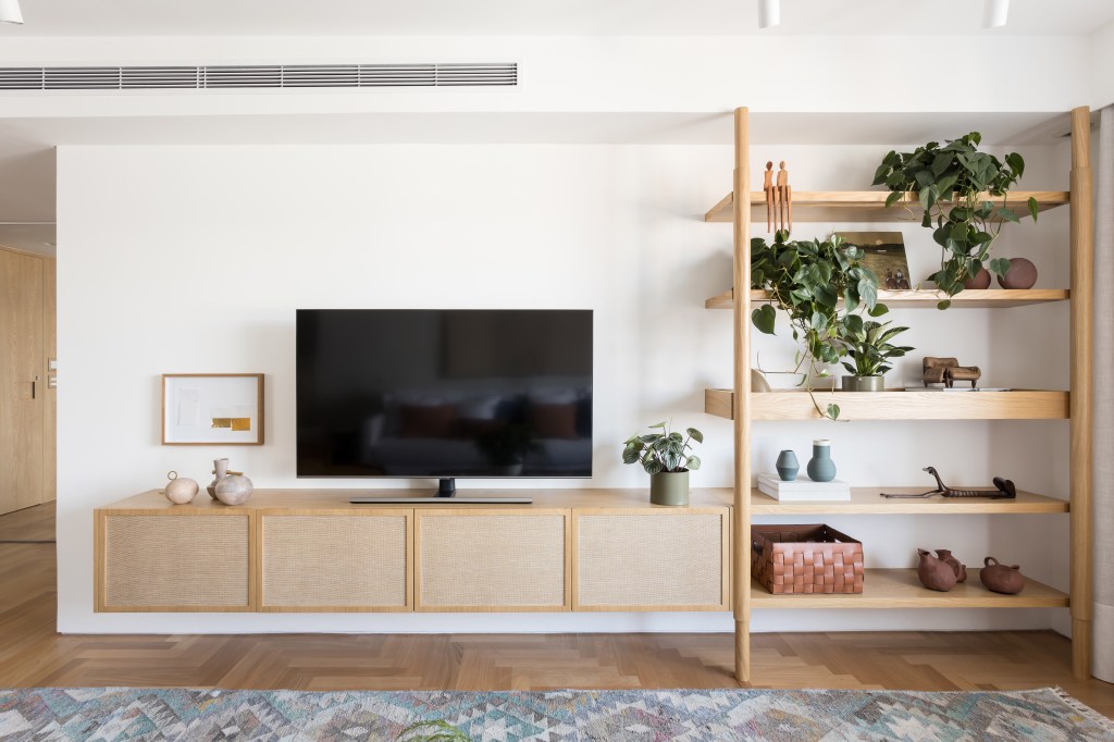 Apto Brooklin Novo Apê eclético: minimalismo, shabby chic e industrial se mesclam em 180 m². Projeto Studio Lak. Na foto, sala de estar com aparador, estante e tv,