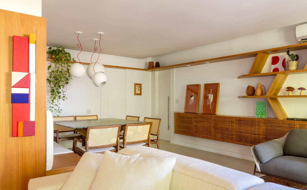 madeira-protagonista-apartamento-117-m2-gavea-mariana-monnerat-credito-lilia-mendel (6) A madeira é a protagonista deste apartamento de 117 m² na Gávea. Projeto de Mariana Monnerat, Na foto, sala de jantar com aparador e quadros.