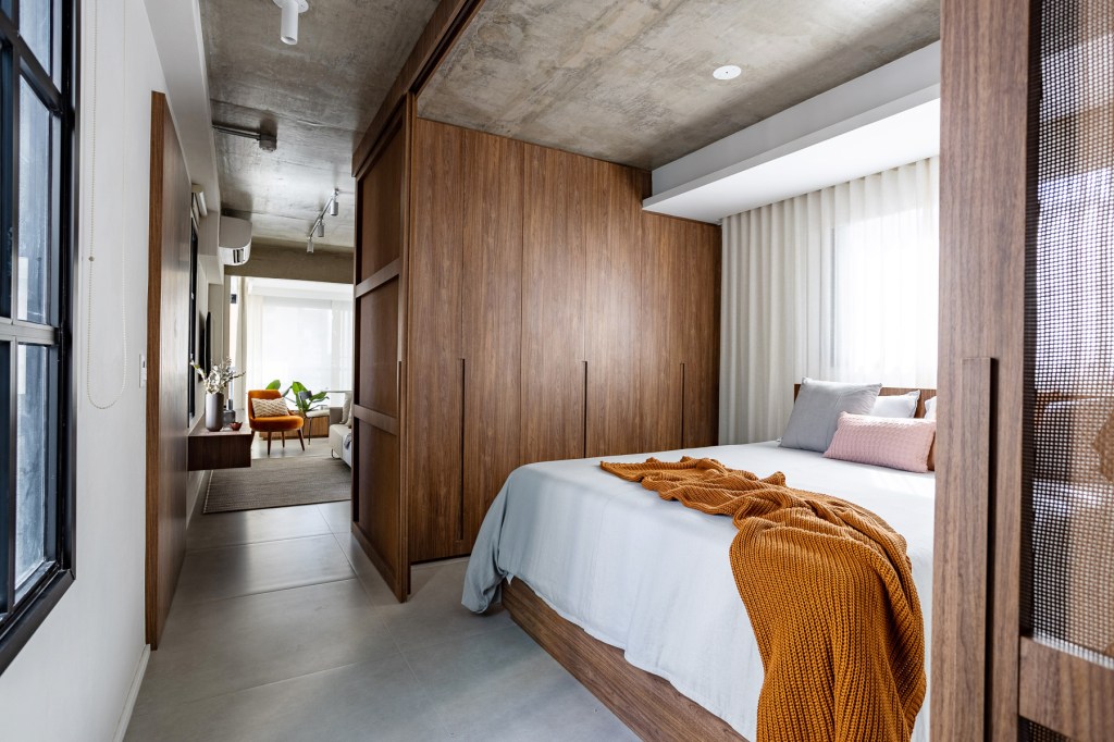 jp-image.com Wabi-sabi norteia a decoração de apartamento de apenas 48 m². Projeto de Carolina Gava. Na foto. quarto com porta de correr e armários.