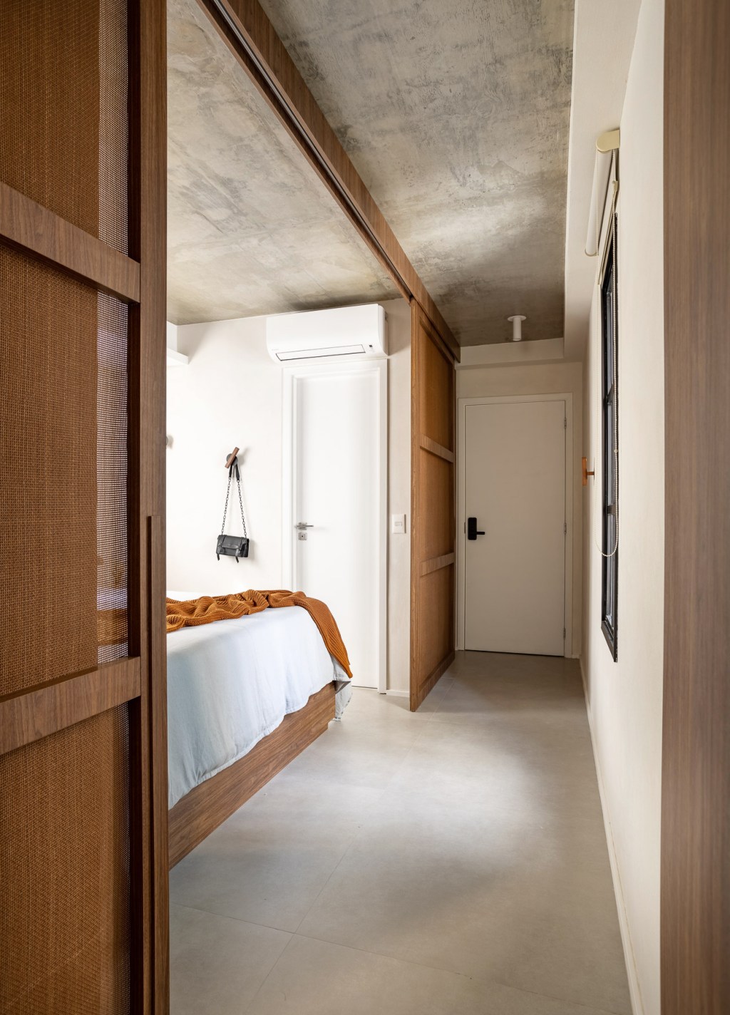 jp-image.com Wabi-sabi norteia a decoração de apartamento de apenas 48 m². Projeto de Carolina Gava. Na foto. quarto com porta de correr e armários.