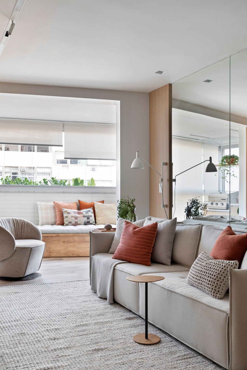 apartamento-70-m2-maior-decor-tons-neutros-fabiano-ravaglia-credito-denilson-machado (3) Apartamento de 70 m² parece maior com décor em tons neutros. Projeto de Fabiano Ravaglia. Na foto, sala de estar com sofá e parede espelhada.