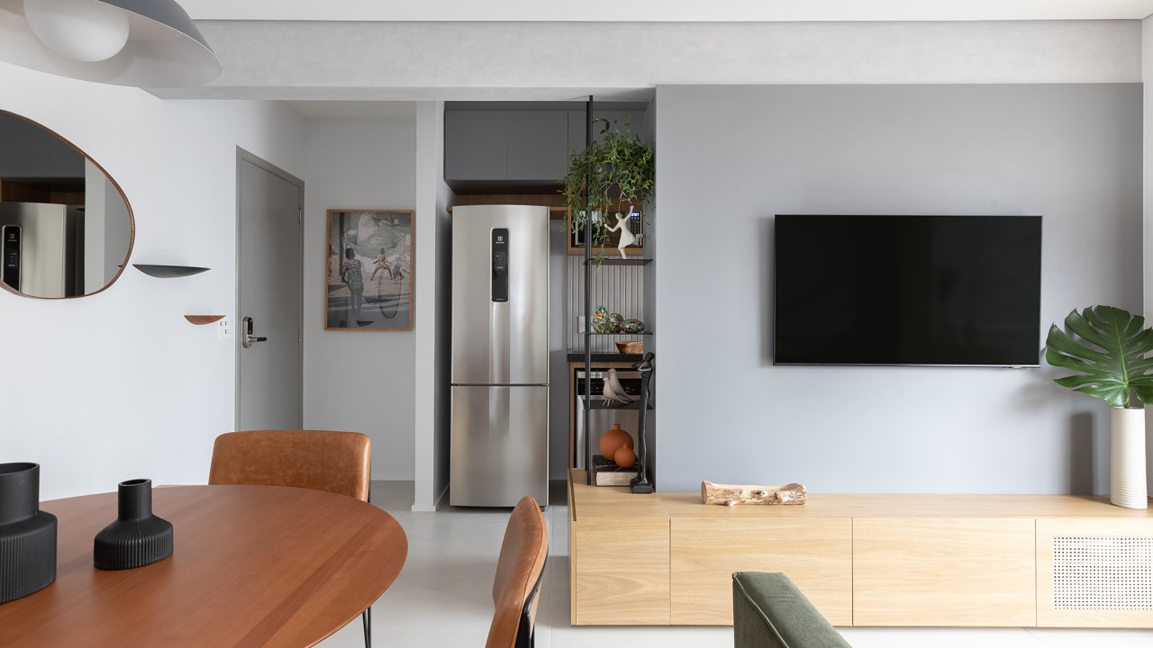 Estilo japandi permeia todo o décor deste apartamento de apenas 53 m². Projeto de Studio Monfré, Na foto, sala de estar e jantar integradas e estante vazada.