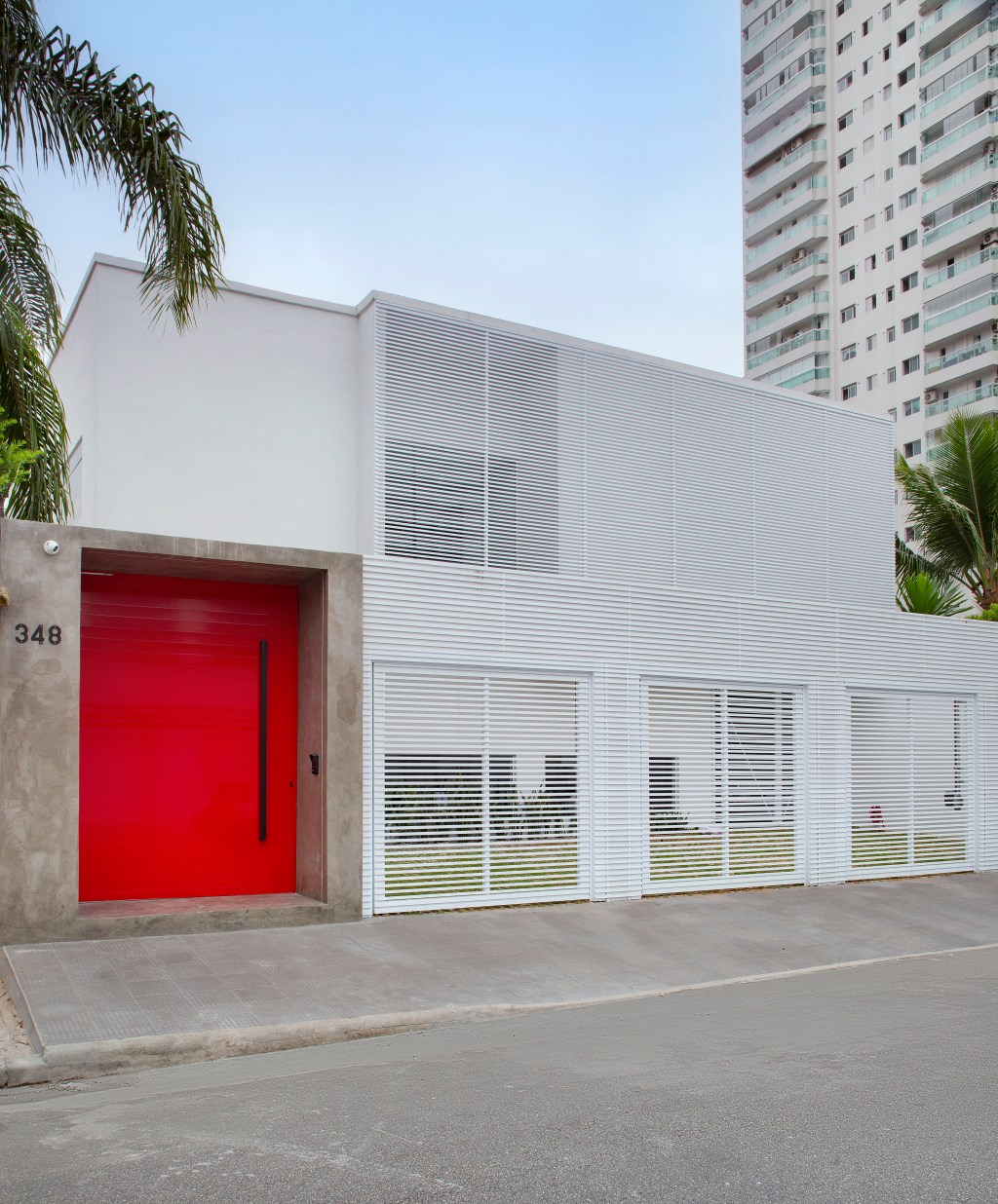 paixao-automobilismo-norteia-projeto-casa-praia-gabriel-fernandes-credito-denilson-machado (22) Paixão pelo automobilismo norteia o projeto desta casa de praia. Projeto de Gabriel Fernandes. Na foto, fachada com porta vermelha.
