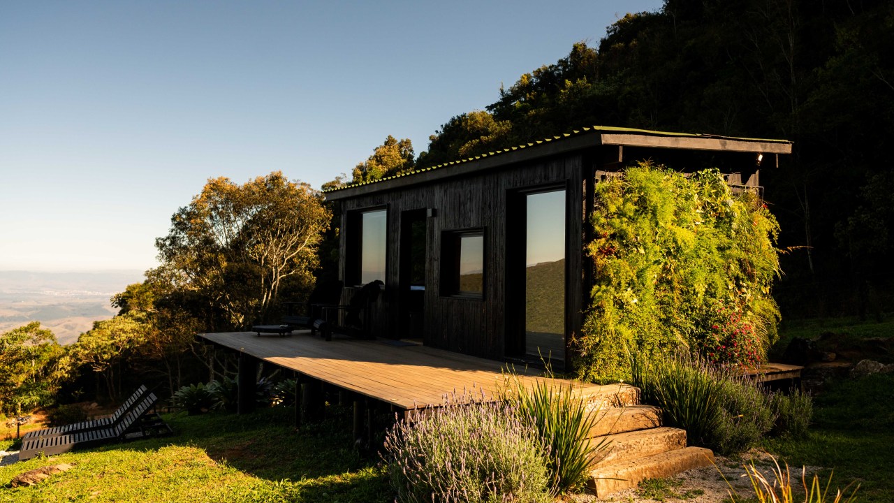 Tiny house sustentável fica a 1500 m de altitude na região serrana de SP. Projeto de Ricardo Delgallo. Na foto, fachada da casa em meio às montanhas.