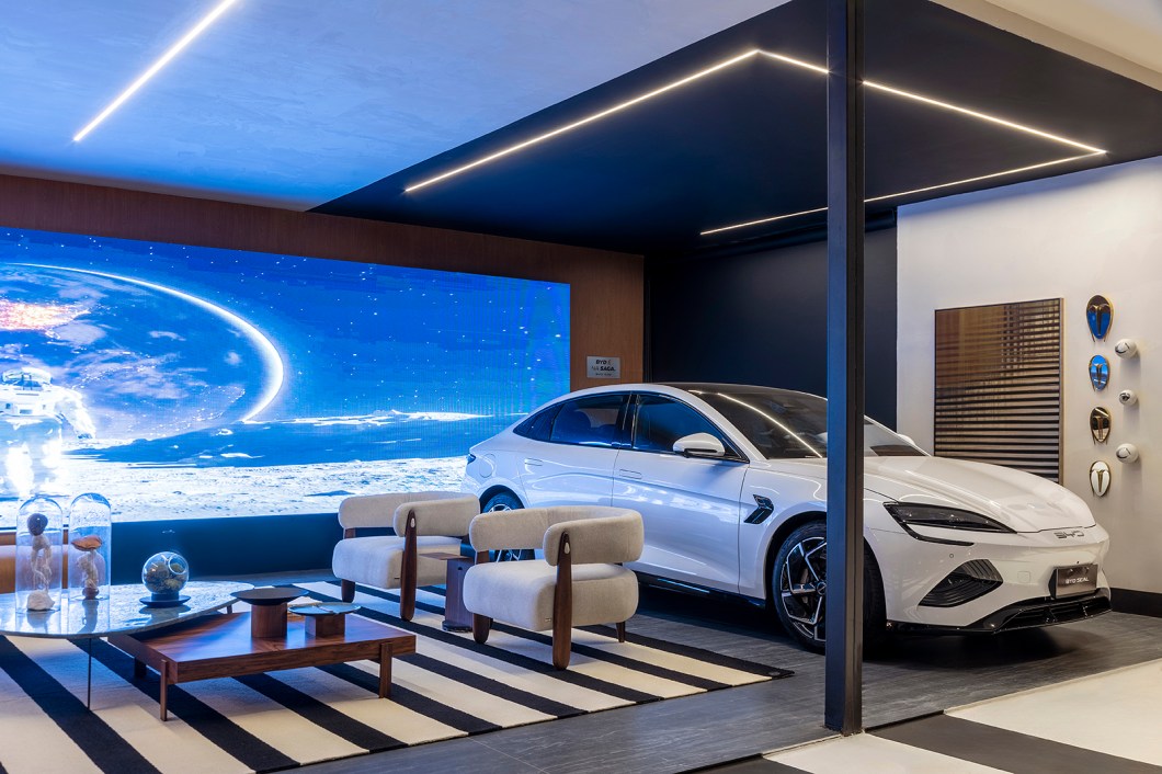 <b>Aline Torres e Thiago Cardoso - Garagem.</b> Os arquitetos Aline Torres e Thiago Cardoso assinam a Garagem, que tem como premissa desmistificar a proposta de ser um espaço unicamente destinado a guardar o carro e funcionar como um lugar de lazer. Como a tecnologia como ponto principal, o ambiente foi dividido em três espaços interligados, mas com funções muito bem definidas: o primeiro é a própria garagem, com a função de estacionar o carro; o segundo, o estar, é reservado para uma conversa, descanso e lazer; já o terceiro e último quadrante é dedicado ao bar, um espaço de confraternização. Além disso, o ambiente homenageia o cantor e compositor brasiliense Hungria, trazendo um espaço que celebra a autenticidade da personalidade e a influência do cantor. <b>Aline Torres e Thiago Cardoso - Garagem.</b> Os arquitetos Aline Torres e Thiago Cardoso assinam a Garagem, que tem como premissa desmistificar a proposta de ser um espaço unicamente destinado a guardar o carro e funcionar como um lugar de lazer. Como a tecnologia como ponto principal, o ambiente foi dividido em três espaços interligados, mas com funções muito bem definidas: o primeiro é a própria garagem, com a função de estacionar o carro; o segundo, o estar, é reservado para uma conversa, descanso e lazer; já o terceiro e último quadrante é dedicado ao bar, um espaço de confraternização. Além disso, o ambiente homenageia o cantor e compositor brasiliense Hungria, trazendo um espaço que celebra a autenticidade da personalidade e a influência do cantor.