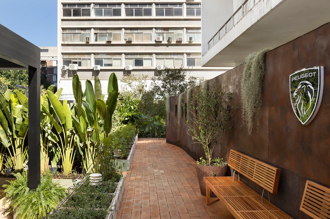 <b>Gil Fialho Paisagismo - Jardim Funcional Peugeot</b>. Um jardim sob medida para a avifauna: nele há refúgio, frutos e néctar não só para as aves como também para os polinizadores, ampliando a biodiversidade de todo o entorno. “É possível criar um microecossistema onde borboletas, beija-flores e outros bichos se sintam bem em uma área urbana rodeada de prédios”, defende o paisagista. Para abrigar o carro elétrico da Peugeot, a garagem com teto retrátil também funciona como lugar de convivência. A densa massa vegetal ao longo dos 200 m² celebra as espécies tropicais, ao passo que o varal com plantas epífitas atesta: basta um fio esticado como guia para garantir a presença do verde. <b>Gil Fialho Paisagismo - Jardim Funcional Peugeot</b>. Um jardim sob medida para a avifauna: nele há refúgio, frutos e néctar não só para as aves como também para os polinizadores, ampliando a biodiversidade de todo o entorno. “É possível criar um microecossistema onde borboletas, beija-flores e outros bichos se sintam bem em uma área urbana rodeada de prédios”, defende o paisagista. Para abrigar o carro elétrico da Peugeot, a garagem com teto retrátil também funciona como lugar de convivência. A densa massa vegetal ao longo dos 200 m² celebra as espécies tropicais, ao passo que o varal com plantas epífitas atesta: basta um fio esticado como guia para garantir a presença do verde.