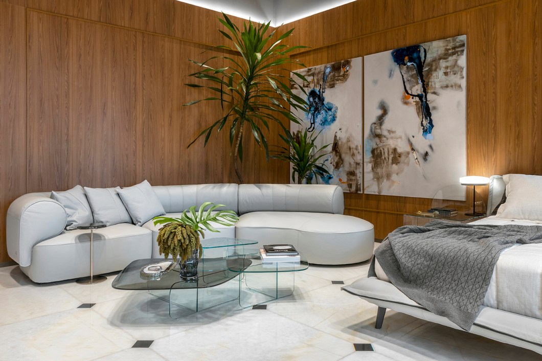 <b>Livia Martins - Espaço Natuzzi. </b>A arquiteta Livia Martins, em sua primeira edição, apresenta o Espaço Natuzzi, um quarto clássico, confortável, com lembranças dos tempos antigos, mas com tecnologia e contemporaneidade. Em destaque, uma grande janela emoldurada com um banco convida o visitante a viajar por suas memórias. Móveis de couro cinza complementam o ambiente totalmente envelopado em madeira, em referência ao passado. Cores escuras nas paredes e nos tetos trazem uma sensação de rebaixamento que promove conforto ao quarto. Por fim, o piso de mármore adiciona um toque de refinamento ao espaço. <b>Livia Martins - Espaço Natuzzi. </b>A arquiteta Livia Martins, em sua primeira edição, apresenta o Espaço Natuzzi, um quarto clássico, confortável, com lembranças dos tempos antigos, mas com tecnologia e contemporaneidade. Em destaque, uma grande janela emoldurada com um banco convida o visitante a viajar por suas memórias. Móveis de couro cinza complementam o ambiente totalmente envelopado em madeira, em referência ao passado. Cores escuras nas paredes e nos tetos trazem uma sensação de rebaixamento que promove conforto ao quarto. Por fim, o piso de mármore adiciona um toque de refinamento ao espaço.