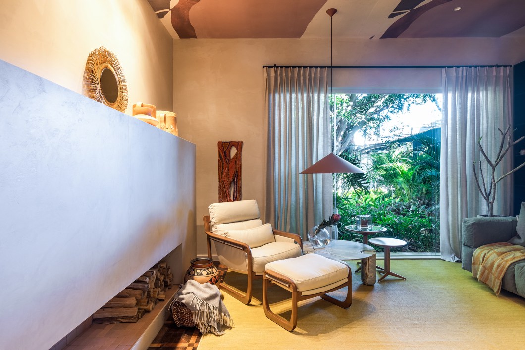 <b>Carla Grudtner - Sala da Lareira.</b> Inspirada em espaços minimalistas que exalam relaxamento, esta sala convida os visitantes ao descanso. O piso e o teto originais do casarão são preservados, assim como a abertura de vidro que permite a incidência de luz natural e proporciona vista para o jardim. O projeto aposta num layout limpo, com formas simples e cores neutras, para destacar a lareira volumétrica desenhada pela arquiteta. Este é o grande destaque da sala, que somado aos móveis soltos de design assinado, cria uma atmosfera aconchegante para os dias mais frios e encantadora em qualquer tempo. <b>Carla Grudtner - Sala da Lareira.</b> Inspirada em espaços minimalistas que exalam relaxamento, esta sala convida os visitantes ao descanso. O piso e o teto originais do casarão são preservados, assim como a abertura de vidro que permite a incidência de luz natural e proporciona vista para o jardim. O projeto aposta num layout limpo, com formas simples e cores neutras, para destacar a lareira volumétrica desenhada pela arquiteta. Este é o grande destaque da sala, que somado aos móveis soltos de design assinado, cria uma atmosfera aconchegante para os dias mais frios e encantadora em qualquer tempo.