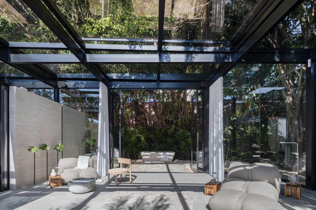 <b>Elaine Zanon e Claudia Machado - Refúgio DECA. </b>A experiência sensorial começa num espaço quadrado integrado, que abriga o spa urbano e se abre para um jardim com forma orgânica. O ponto alto do projeto é a estrutura de vidro, com paredes soltas em mármore travertino extra levigado, que cria áreas internas e externas de relaxamento com os produtos Deca. Essa integração com a natureza circundante traz a água como fonte de reconexão profunda, que retorna à ancestralidade e se estende ao mundo interior. A arquitetura é meticulosamente pensada para que o espaço transcenda os limites físicos, num ambiente que não apenas convida à contemplação, mas também instiga os visitantes a olhar para fora de si. <b>Elaine Zanon e Claudia Machado - Refúgio DECA. </b>A experiência sensorial começa num espaço quadrado integrado, que abriga o spa urbano e se abre para um jardim com forma orgânica. O ponto alto do projeto é a estrutura de vidro, com paredes soltas em mármore travertino extra levigado, que cria áreas internas e externas de relaxamento com os produtos Deca. Essa integração com a natureza circundante traz a água como fonte de reconexão profunda, que retorna à ancestralidade e se estende ao mundo interior. A arquitetura é meticulosamente pensada para que o espaço transcenda os limites físicos, num ambiente que não apenas convida à contemplação, mas também instiga os visitantes a olhar para fora de si.