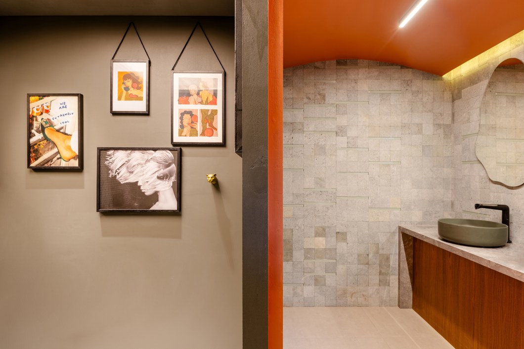 <b>Fernanda Gonçalves - Capsula Sensorial.</b> Inspirada por um recente estudo da neuroarquitetura, a profissional cria um ambiente que brinca com os estímulos sensoriais e explora os diferentes sentidos. Neste banheiro, elementos funcionais se somam a uma abordagem artística. O hall traz cores vibrantes que evocam energia e vitalidade, e a iluminação indireta adiciona movimento e drama. As cabines se conectam com o hall, a primeira com os tons de verdes e as cubas, e a segunda com as nuances escuras e os detalhes curvos do forro. A tela tensionada arremata o projeto com um toque industrial e urbano, compondo com a parede de obras assinadas por artistas locais. <b>Fernanda Gonçalves - Capsula Sensorial.</b> Inspirada por um recente estudo da neuroarquitetura, a profissional cria um ambiente que brinca com os estímulos sensoriais e explora os diferentes sentidos. Neste banheiro, elementos funcionais se somam a uma abordagem artística. O hall traz cores vibrantes que evocam energia e vitalidade, e a iluminação indireta adiciona movimento e drama. As cabines se conectam com o hall, a primeira com os tons de verdes e as cubas, e a segunda com as nuances escuras e os detalhes curvos do forro. A tela tensionada arremata o projeto com um toque industrial e urbano, compondo com a parede de obras assinadas por artistas locais.
