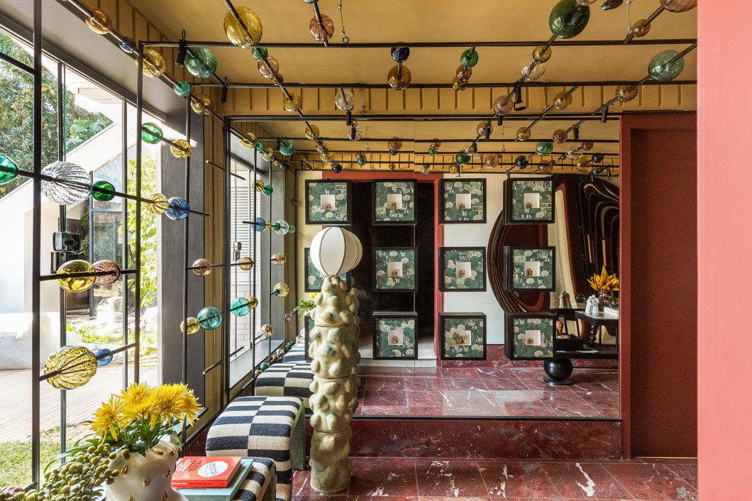<b>Karolinna Venturi - Hall da Casa. </b>Este espaço do casarão rememora os arquitetos de antigamente, tempos em que eles próprios desenvolviam as peças de seus projetos, pois as opções eram escassas. Para o desenho do ambiente, a arquiteta se inspira na alta costura, em que tudo é feito sob medida e cada criação é exclusiva. Tendo a arte como protagonista, a composição é marcada pela explosão de cores e mistura de materiais. As peças desenhadas especialmente para o projeto são os destaques, tais como: estrutura do teto com vidros de murano, luminária confeccionada por ceramista, peça do aparador com aplicação de uma obra de artista local, estante garimpada em antiquário e banco de apoio revestido com tapetes. <b>Karolinna Venturi - Hall da Casa. </b>Este espaço do casarão rememora os arquitetos de antigamente, tempos em que eles próprios desenvolviam as peças de seus projetos, pois as opções eram escassas. Para o desenho do ambiente, a arquiteta se inspira na alta costura, em que tudo é feito sob medida e cada criação é exclusiva. Tendo a arte como protagonista, a composição é marcada pela explosão de cores e mistura de materiais. As peças desenhadas especialmente para o projeto são os destaques, tais como: estrutura do teto com vidros de murano, luminária confeccionada por ceramista, peça do aparador com aplicação de uma obra de artista local, estante garimpada em antiquário e banco de apoio revestido com tapetes.