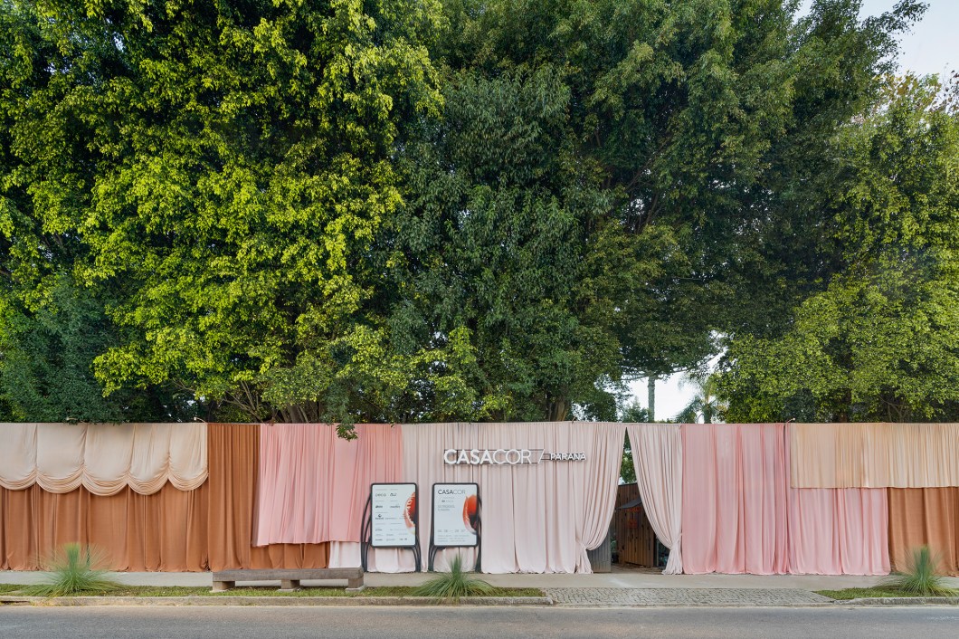 <b>Nicholas Oher e Paloma Bresolin - Fachada. </b>A fachada da CASACOR Paraná é mais do que a face principal do casarão que sedia a mostra, é a promessa de uma experiência visual envolvente. O tema deste ano inspira os profissionais a oferecer um presente arquitetônico para Curitiba, transcendendo a norma de maneira inédita. A partir deste conceito, a construção é embrulhada com uma cortina de 30 metros de largura, que mescla diferentes texturas, volumes e tamanhos. A paleta cromática contempla tons de goiaba, pêssego, caju e rosa, todos conectados com sensações positivas. Toda a composição visa incentivar o cuidado com a beleza da vida que nos circunda. <b>Nicholas Oher e Paloma Bresolin - Fachada. </b>A fachada da CASACOR Paraná é mais do que a face principal do casarão que sedia a mostra, é a promessa de uma experiência visual envolvente. O tema deste ano inspira os profissionais a oferecer um presente arquitetônico para Curitiba, transcendendo a norma de maneira inédita. A partir deste conceito, a construção é embrulhada com uma cortina de 30 metros de largura, que mescla diferentes texturas, volumes e tamanhos. A paleta cromática contempla tons de goiaba, pêssego, caju e rosa, todos conectados com sensações positivas. Toda a composição visa incentivar o cuidado com a beleza da vida que nos circunda.